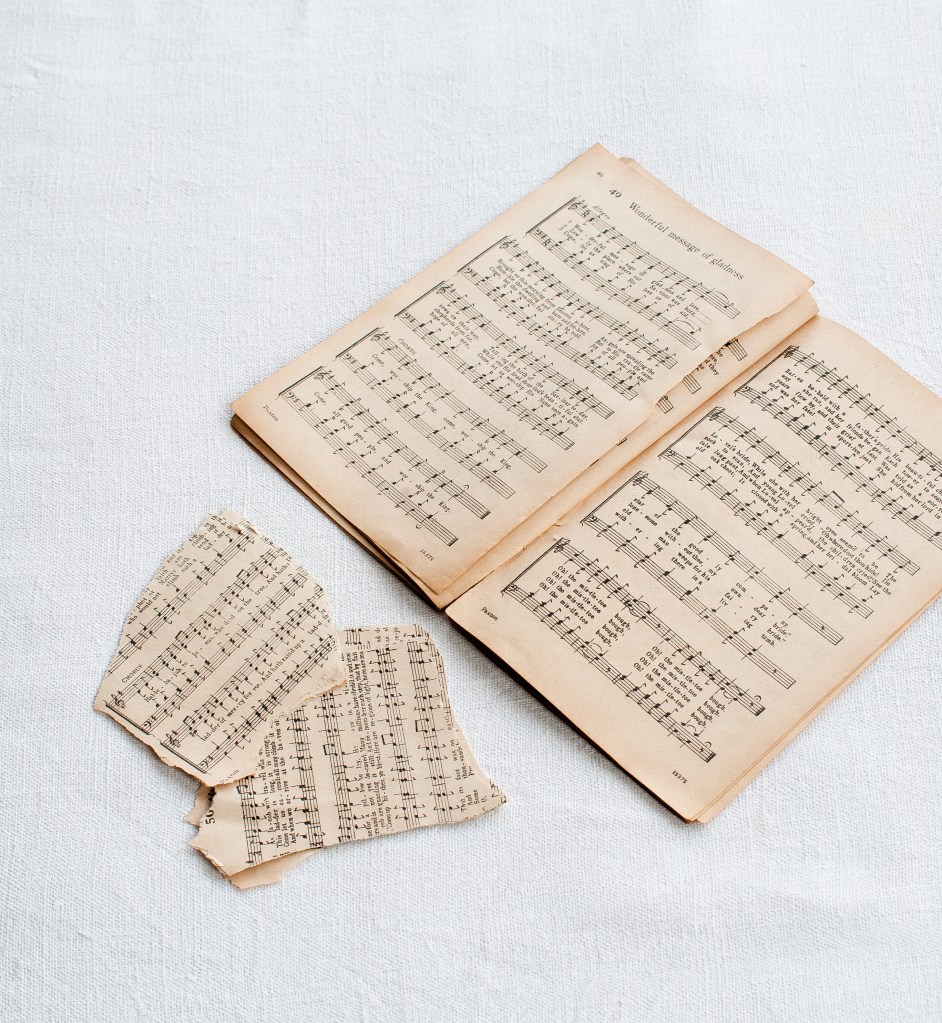 Step 2 Picture, old and yellowed music sheets and some torn up pieces of paper next to them
